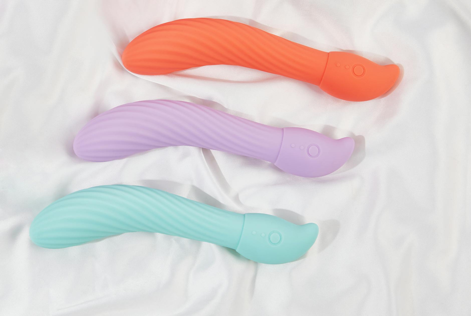 A hand holding a blue silicone vibrator against a solid purple background, promoting self-love and pleasure.