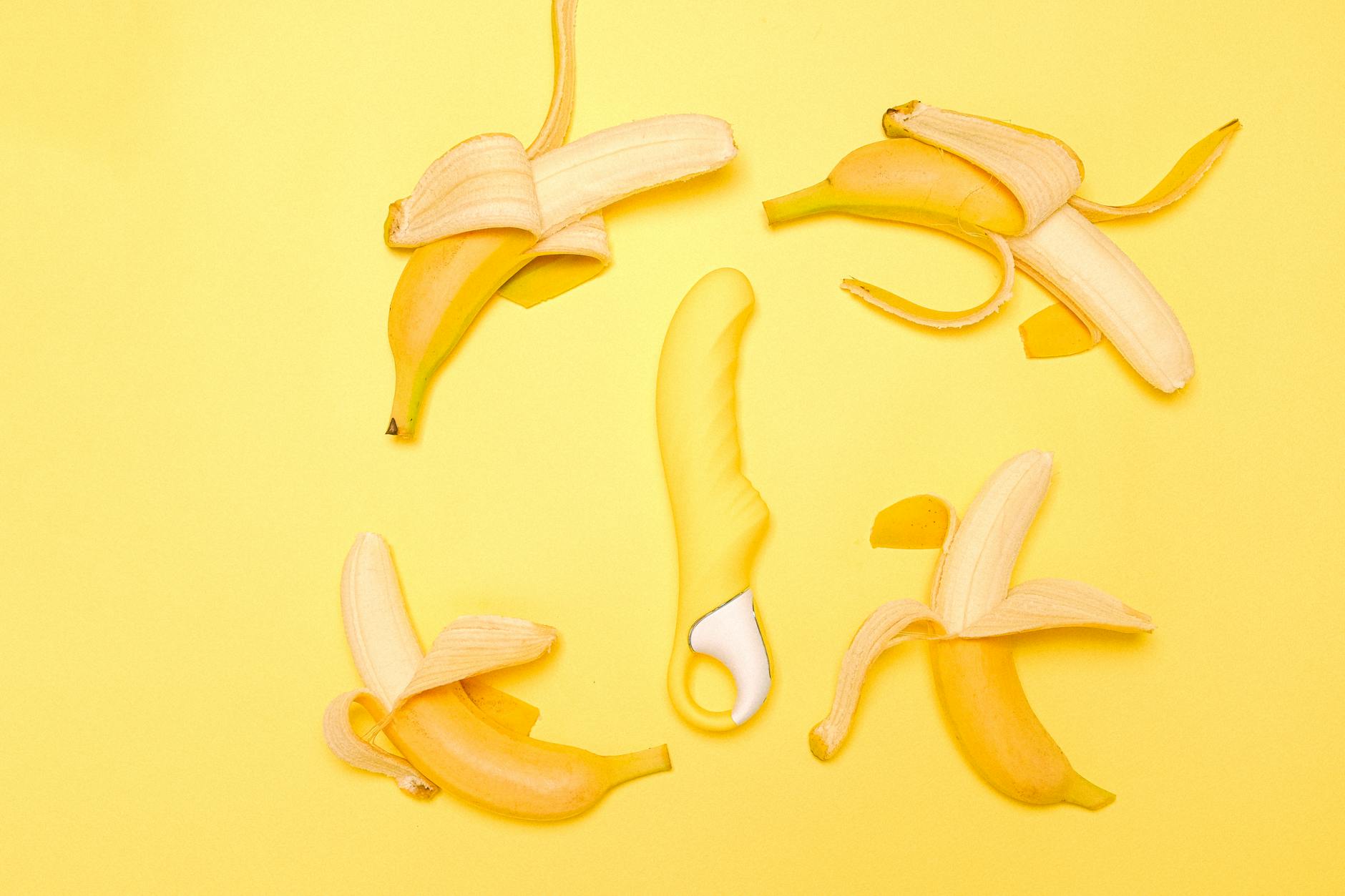 Yellow lemon vibrator surrounded by fresh lemons on yellow background, symbolizing rediscovery of pleasure