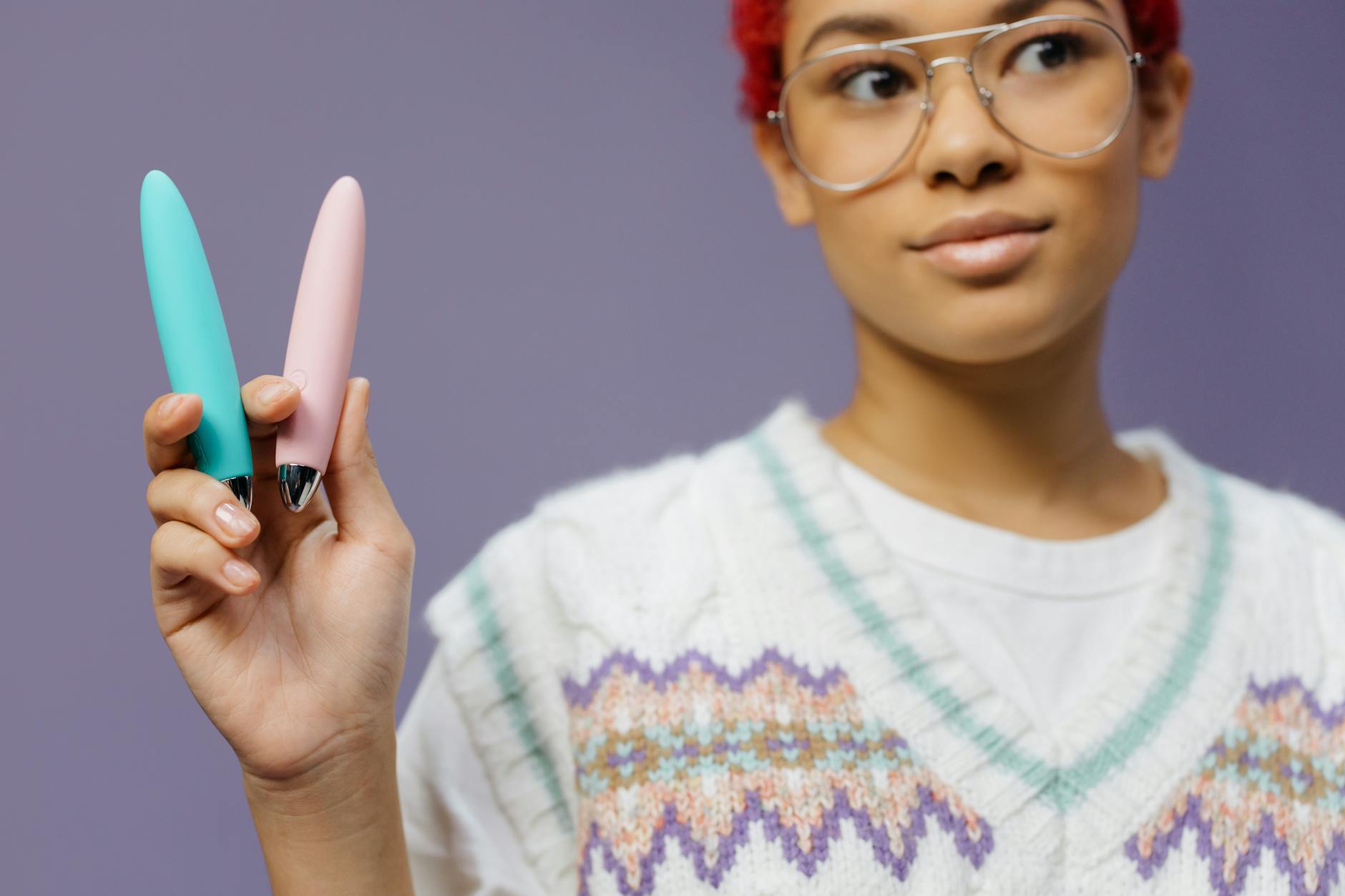 A woman holds vibrators against a purple background, representing adult toys for couples reconnection