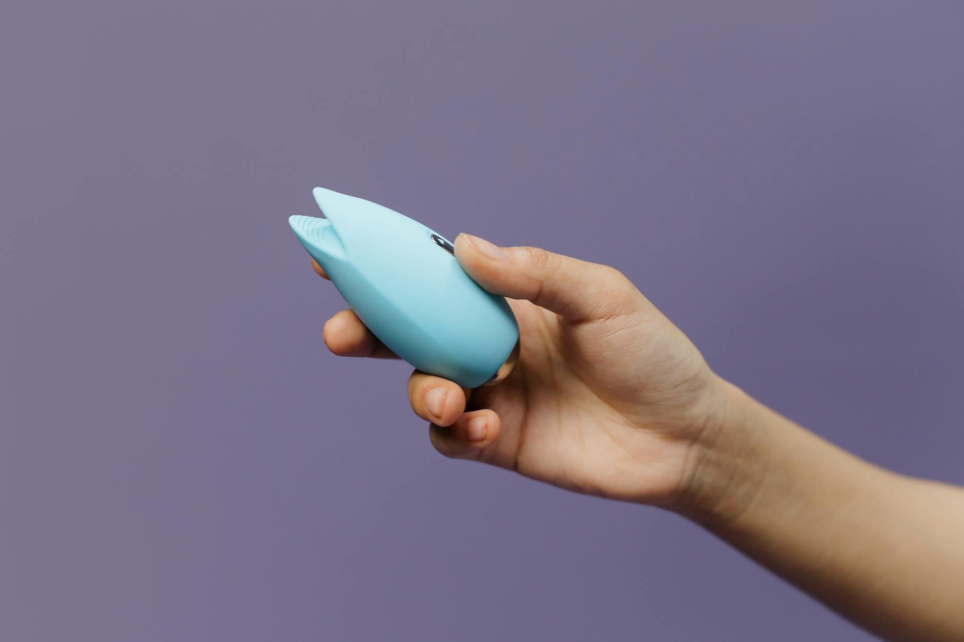 A blue silicone sex toy held in hand, symbolizing the gentle restart of personal pleasure and self-connection.