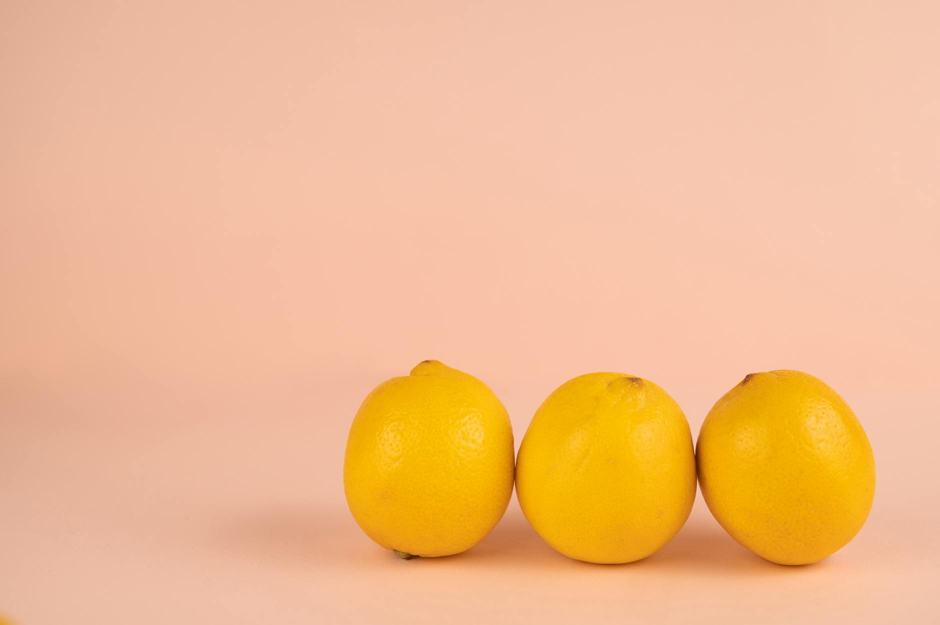 A hand holding a bright lemon against a vivid yellow background, symbolizing fresh sensation and reconnection