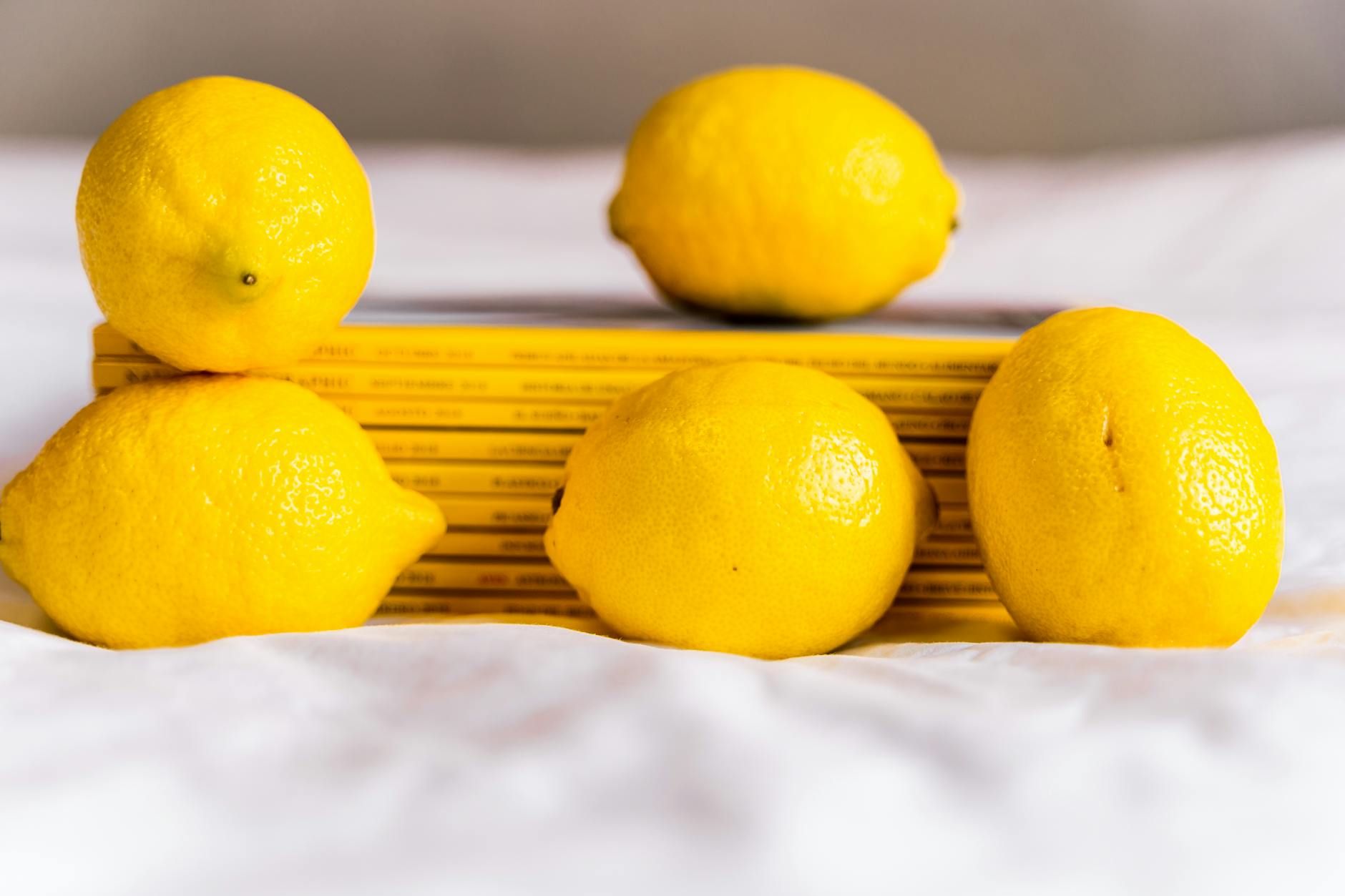 Person holding a fresh lemon at a table, symbolizing renewal and gentle reconnection